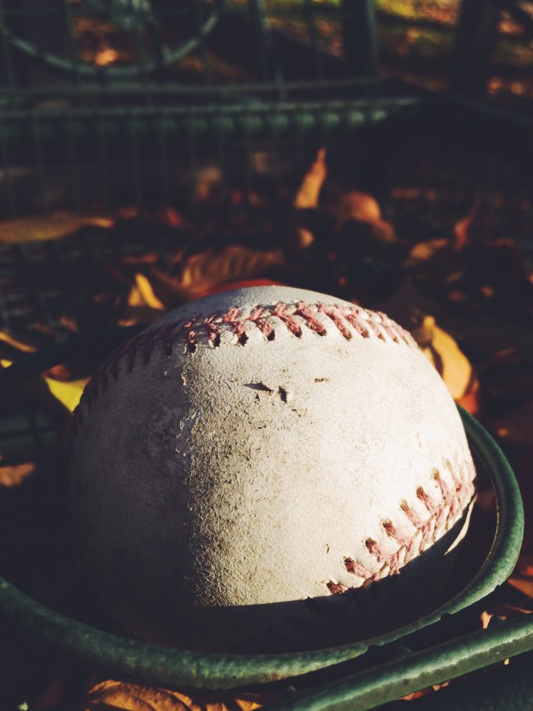 A worn baseball in the winter sun.