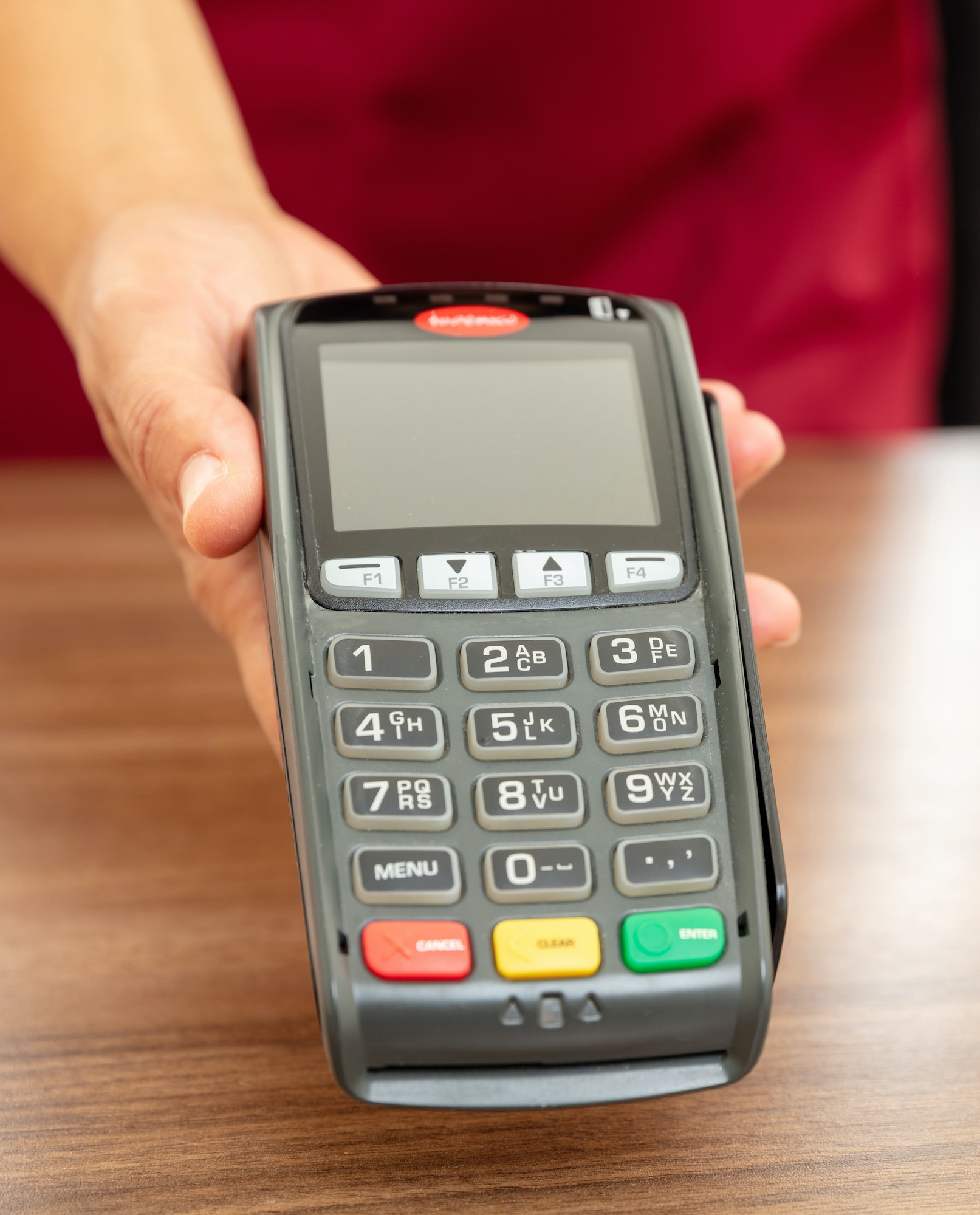 Cashier offering POS terminal for payment with credit card.